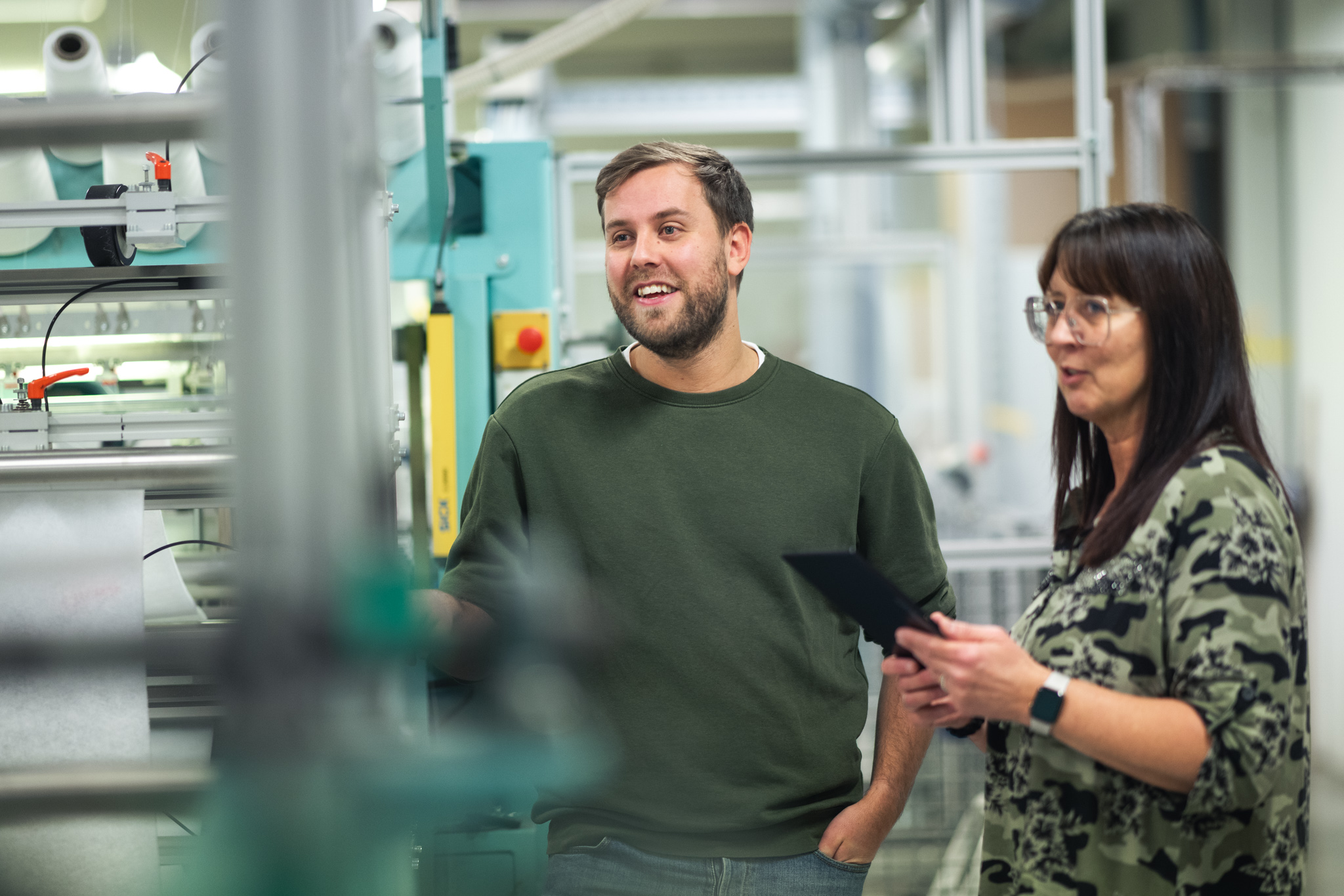 Två personer i samtal i industrimiljö