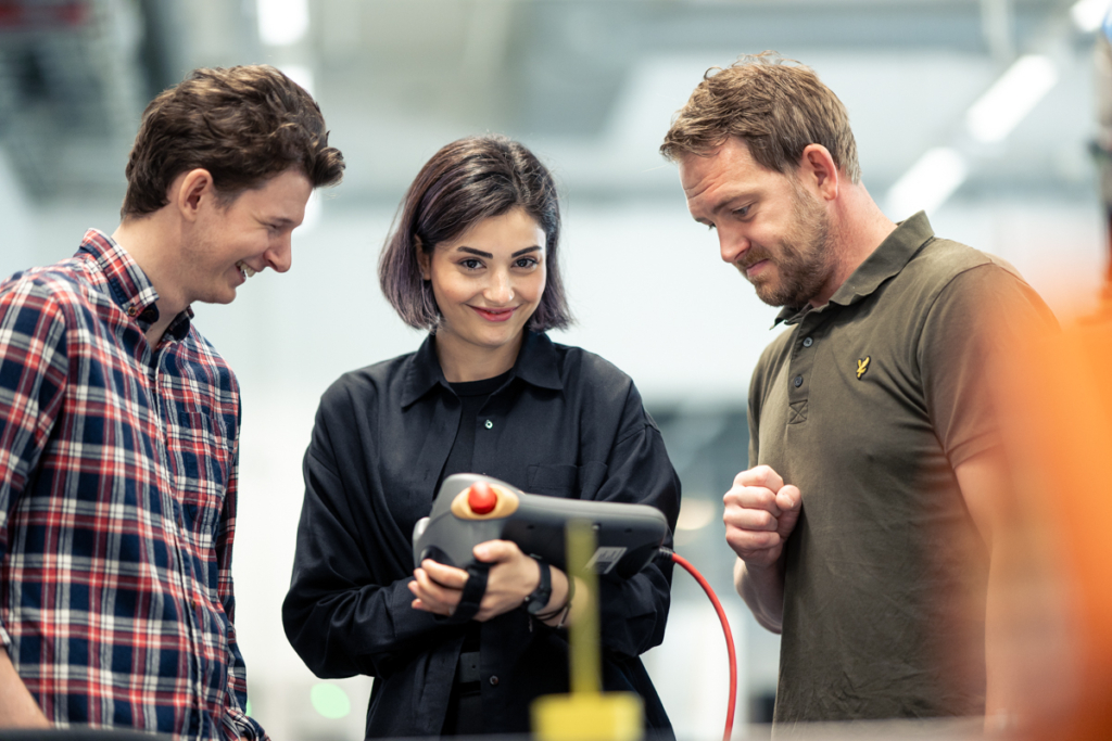 Medarbetare testar digital utrustning i industrimiljö.