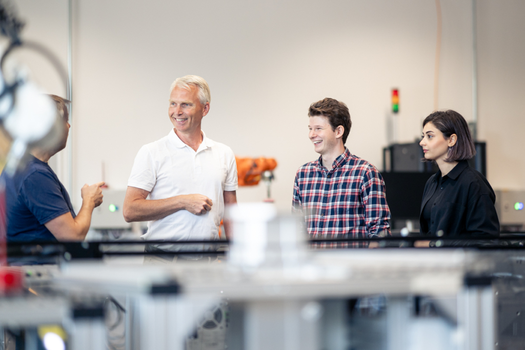 Deltagare i industrinätverk samtalar i produktionsmiljö