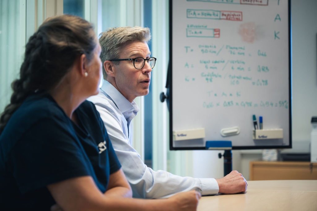 Två personer i möte framför whiteboard