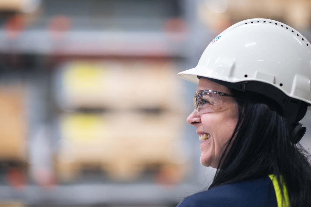 Kvinna i skyddshjälm i industrimiljö