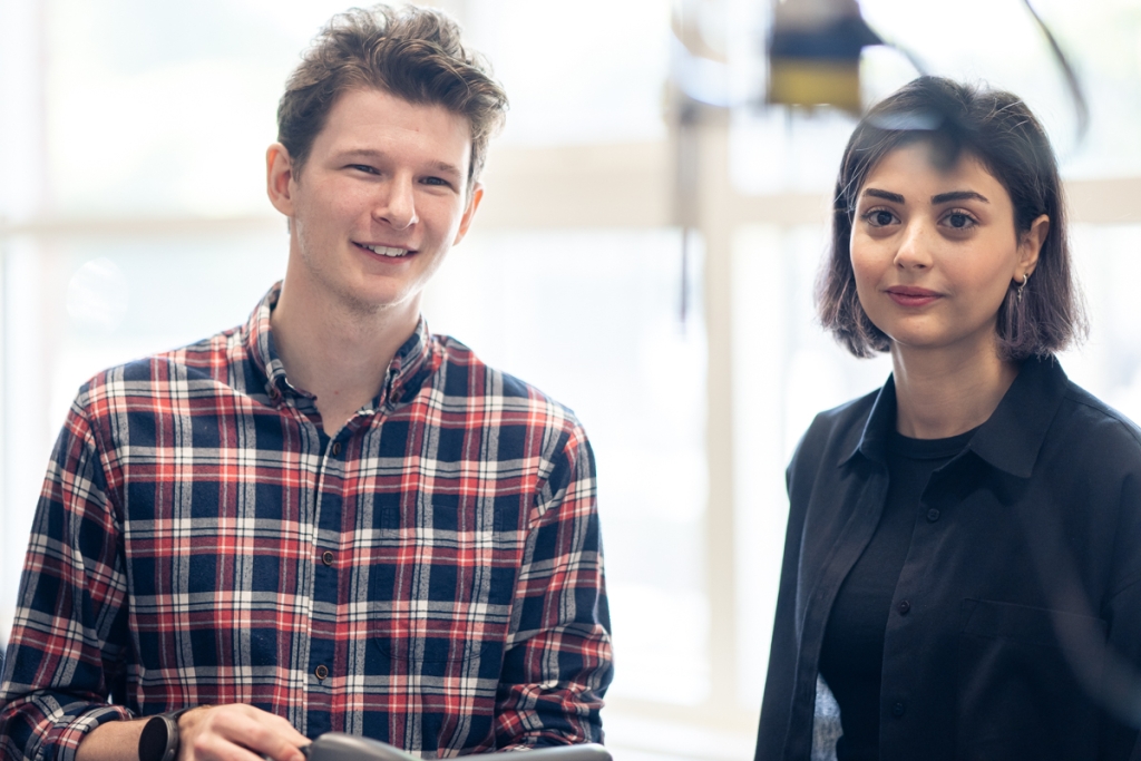 Två unga yrkesverksamma i industrimiljö