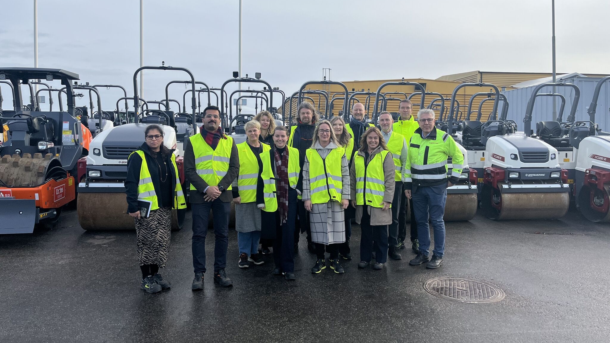 Grupp i varselkläder vid industribesök utomhus