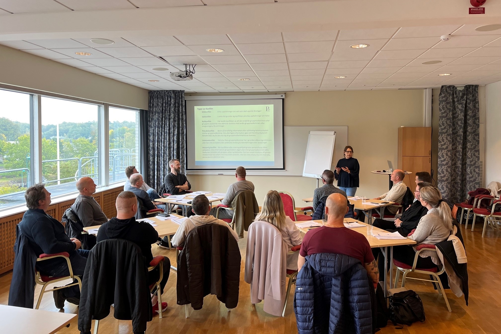 Deltagare på utbildning i konferenslokal med presentation på skärm